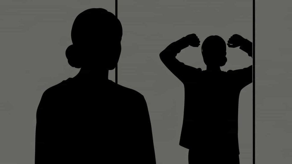 Silhouette of a person seeing a mismatched reflection to symbolize the psychological fear of doubles.