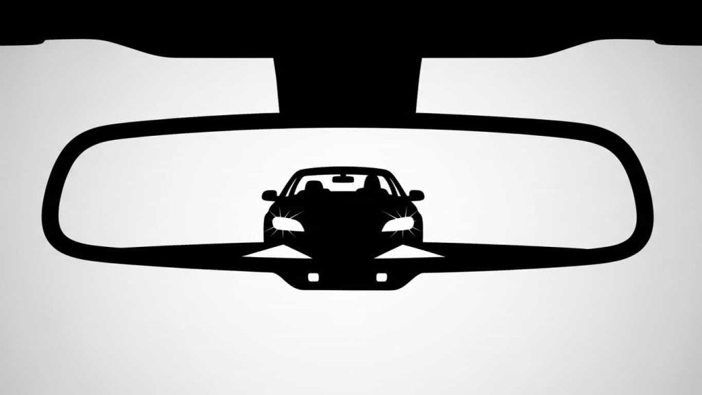 minimal silhouette of rearview mirror reflecting car behind