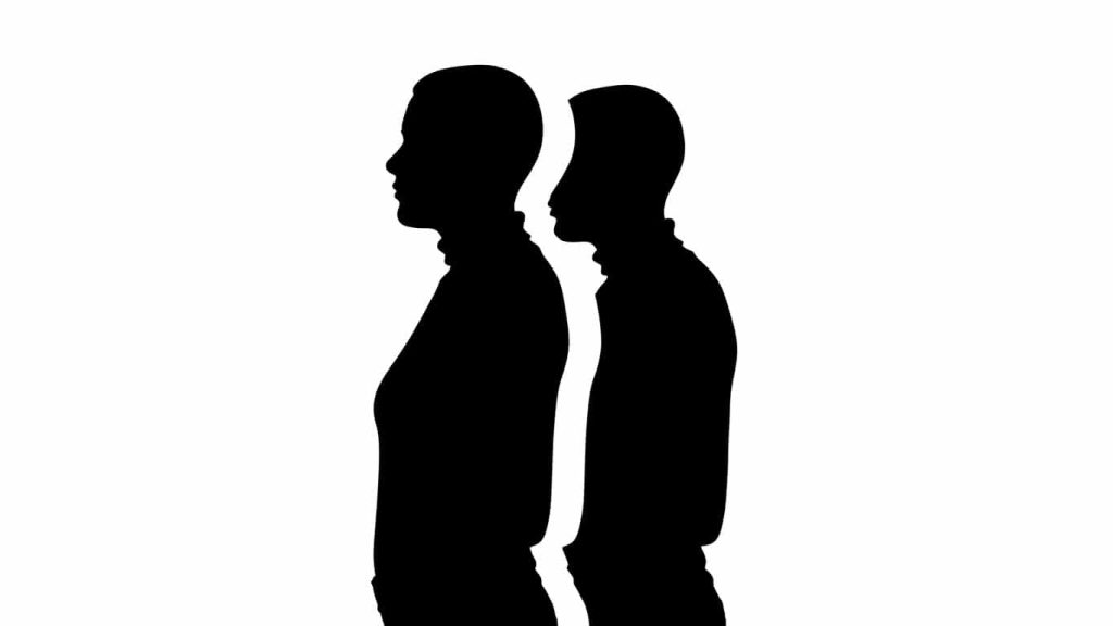 Silhouette of a double standing behind a person to show the threat to individuality.